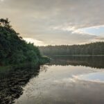 Ein stiller See im Licht der Dämmerung – Sinnbild für Abschied, Ruhe und die zyklische Natur des Lebens.
