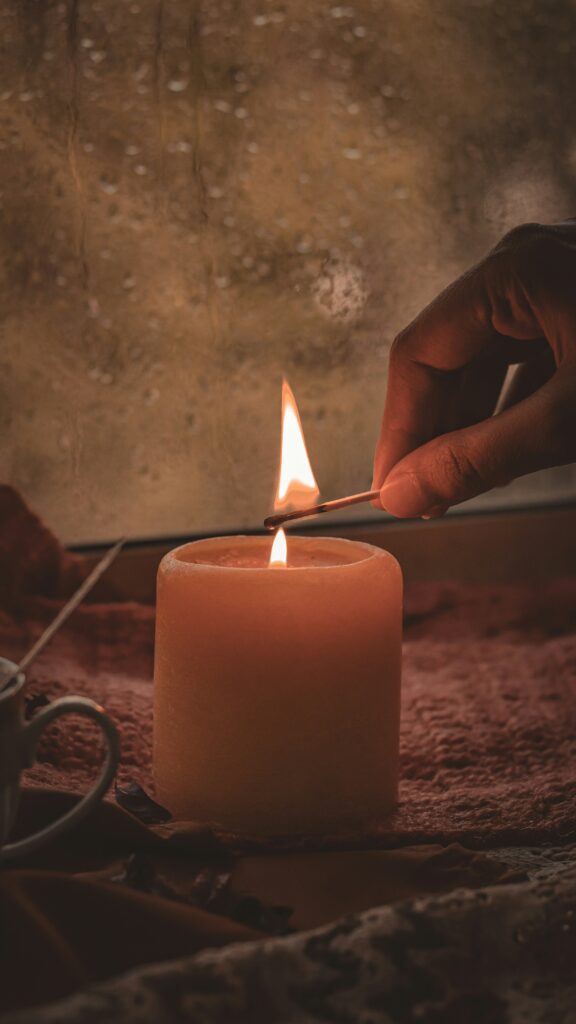 Candlelight symbolizing hygge and emotional warmth during dark winter months; photo by Nav Rashmi Kalsi on Unsplash.