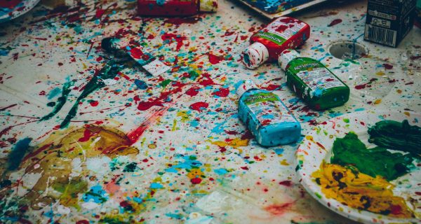 Colorful table with open paint tubes all over it. Photo by Ricardo Viana